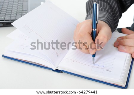 businessman makes a note in notebook. Isolated on white background