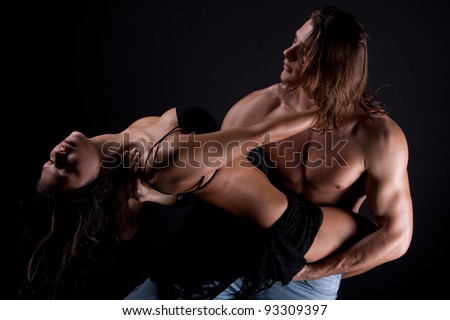 A young man with long hair and a muscular body passionately engaged in sex with a beautiful girl