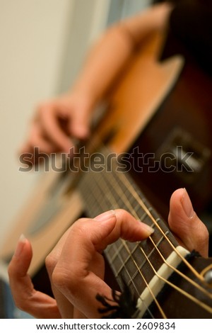 Young woman playing guitar - shallow depth of field