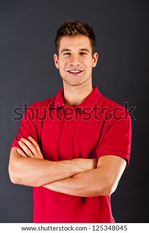 Man on black background in red shirt with smile