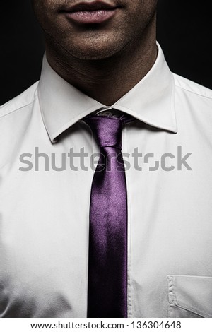 Man with white shirt and tie on black background