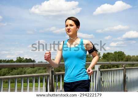 young girl running in the city, over the river by the bridge