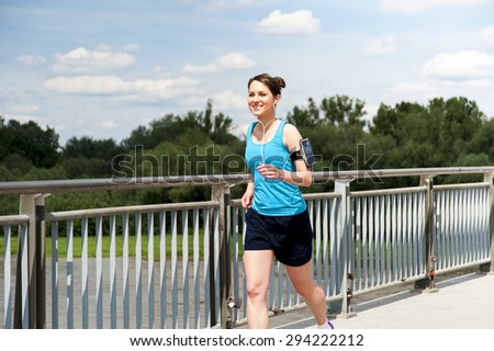 young girl running in the city, over the river by the bridge