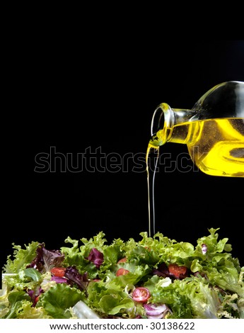 dressing a green salad with olive oil