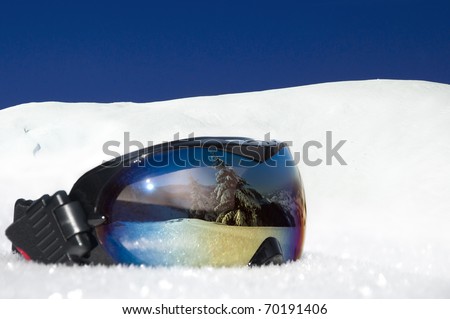 protective eyewear for winter sports and recreation on the background of snowy mountains and blue sky