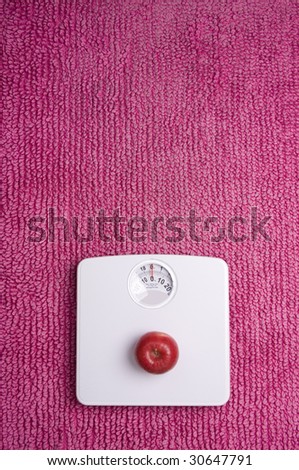 Three apples placed on scales, shot portrait.