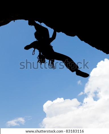 Rock climber silhouette in a sunny day climbing high