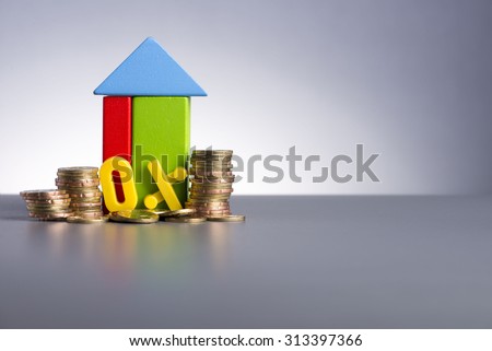 Housing Loan concept. House Wooden Block, coins and 0% toy alphabet
