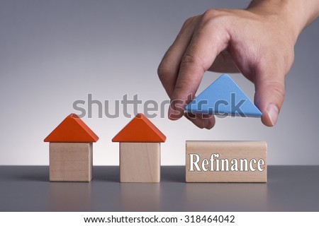 Hand holding wooden house (Housing Loan Concept) with word Refinance