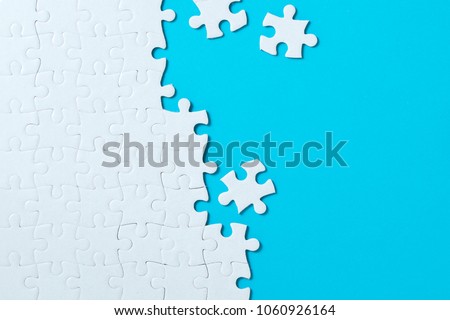 Unfinished white jigsaw puzzle pieces on blue background Сток-фото © 