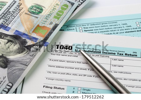 Filling out income tax forms with US dollar and pen