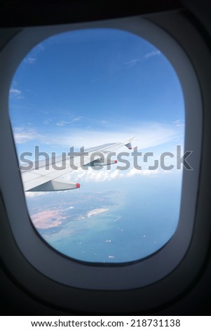 Cloudy blue sky looking through airplane window
