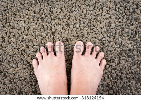 Bare man feet on asphalt floor for reflexology concept