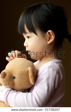 Little girl holding a teddy bear in her hand
