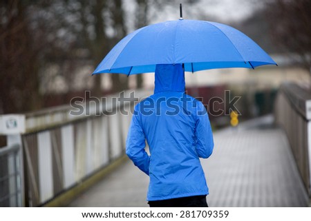 A walking man with umbrella in the rain.