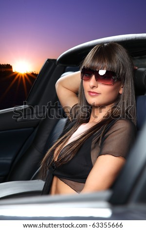 A young lady relaxed in her car during sunset