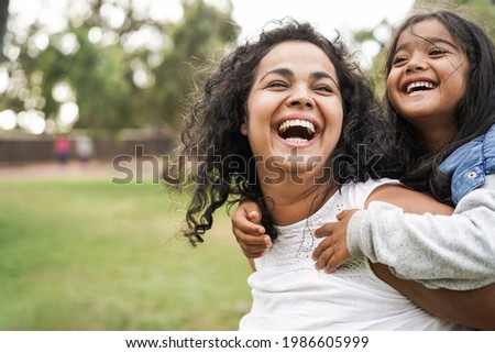 Happy indian mother having fun with her daughter outdoor - Family and love concept - Focus on mum face