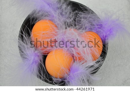 Eggs in a colorful bowl with purple feathers