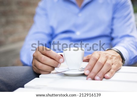 Young fashion man with beard drinking espresso coffee in the city cafe