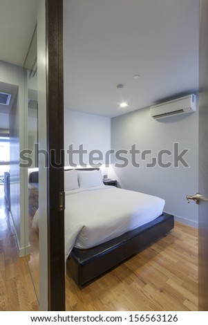 small white bedroom in apartment.