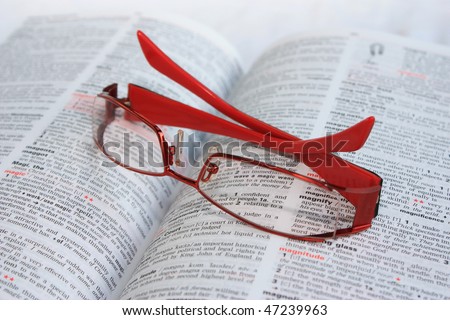 Red frame eye glasses on a dictionary page