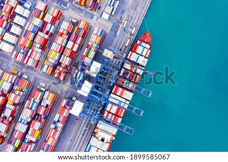 Aerial top view over international cargo ship at industrial import-export port prepare to load containers with big container loader ship vessel. global transportation and logistic business. Stock photo © 