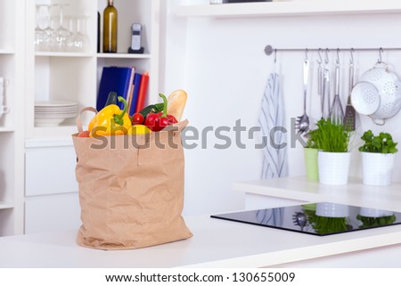 Paper shopping bag full of food on a kitchen counter