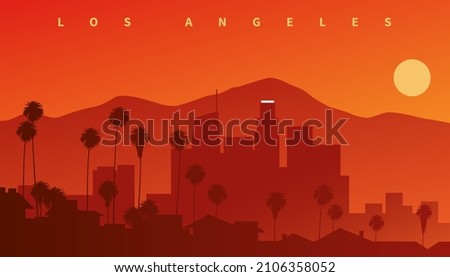 Downtown Los Angeles at sunset. Skyline silhouette with mountains in the background and palms in the foreground, California, USA