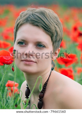 The girl in the field of poppies in the spring