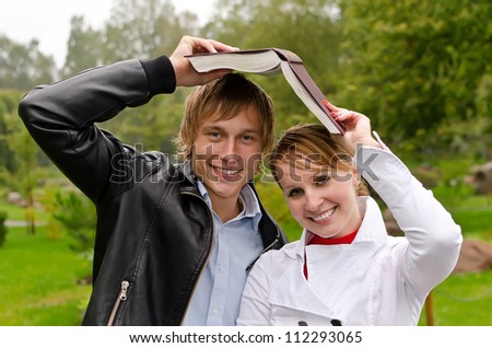 Two students with book in the park
