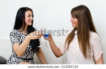 Two female friends drinking cocktail