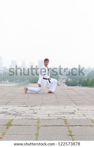 Young karate master doing exercise n the morning on city background Stock fotó © 