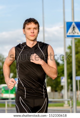 Young handsome sportsman running on the street