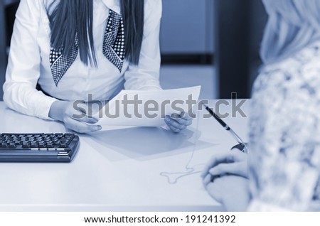 Customer with sales agent at the desk with prepared documents for the deal