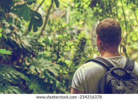 Tourist with backpack in the jungle. Vintage effect. Space for your text.