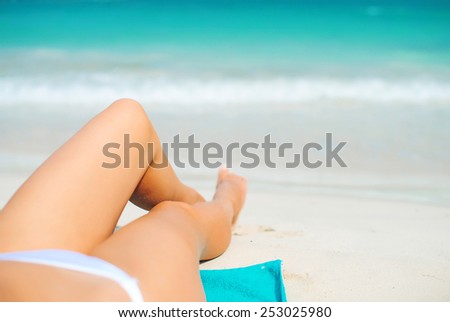 Woman lying on the beach. Legs.