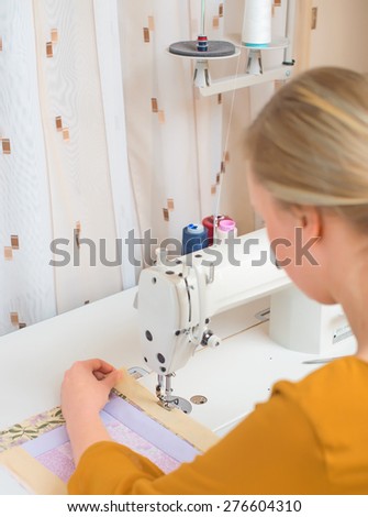 Woman working on sewing machine in the factory.