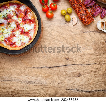 Top view of pizza in iron pan with ingredients. Place for your text.