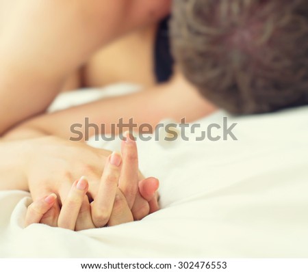 Passionate couple making love in bed.