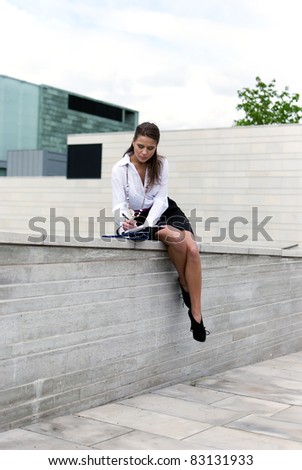 Business woman sitting in a black skirt and sign the document