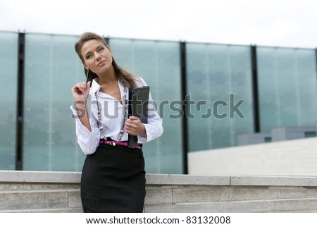 business woman in black skirt and is holding a folder on the business background of the building