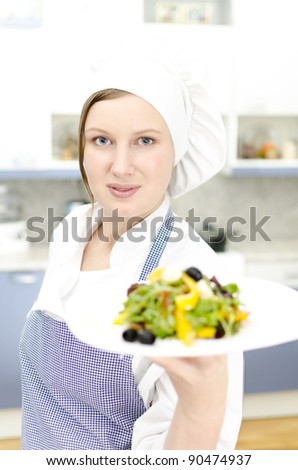 Pretty cook chief holding salad