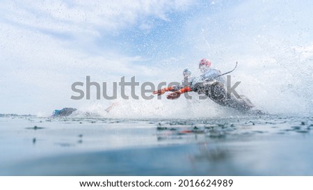 Triathletes in wetsuits run into the water during a triathlon competition Imagine de stoc © 