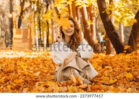 Similar – Image, Stock Photo Beautiful woman in autumn park wearing a burgundy beret, holding a red maple leaf. Young woman with long hair in stylish fall outfit, smiling and looking to the camera.