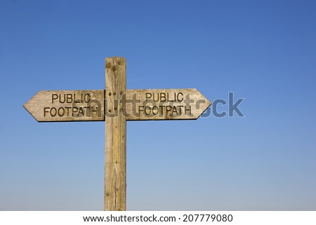 a wooden public footpath sign on a blue sky background