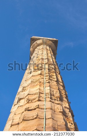 The  old weathered stone navigation light  tower at Whitby harbour on the Yorkshire coast, England, under a blue sky in summer