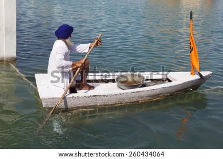 Amritsar Punjab India Feb 22nd 2015. Sikh pool cleaning man in his boat on the holy pool at the Golden Temple Amritsar