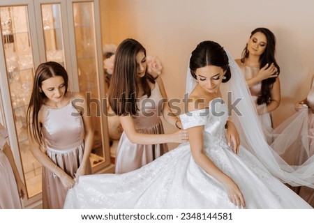 Similar – Image, Stock Photo elegant bride with bridesmaids in the wedding morning preparation. Beautiful bride is dressed up an elegant wedding robe, bridesmaids in grey dresses