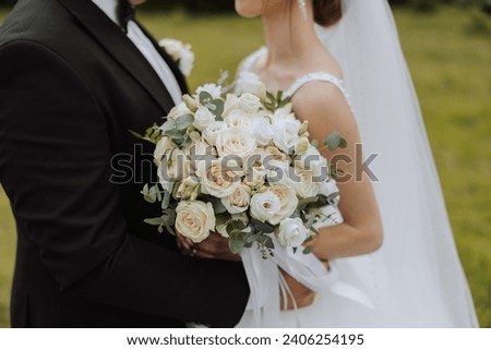 Image, Stock Photo cropped photo of bouquet of wildflowers in woman’s hand. Loving hipster couple walking in the field, kissing and holding hands, hugging, lying in the grass in the summer at sunset. valentines day