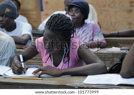 CITE SOLEIL- AUGUST 25:  A female student taking notes in a local community school in Cite Soleil- one of the poorest area in the Western Hemisphere on August 25 2010 in Cite Soleil, Haiti.